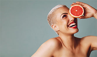 image of woman holding grapefruit slice