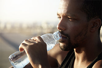 man hydrating drinking from water bottle