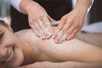 woman being exfoliated at spa