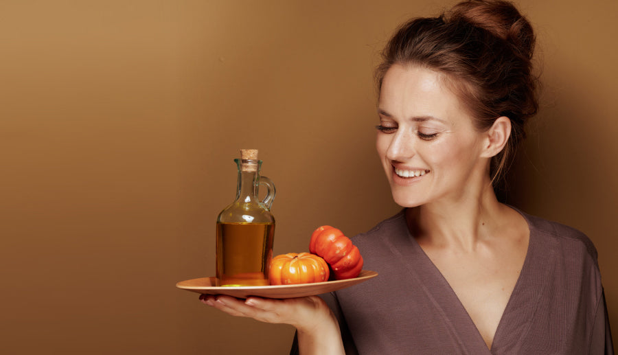 Massage Therapist holding pumpkin and pumpkin oil for treatment