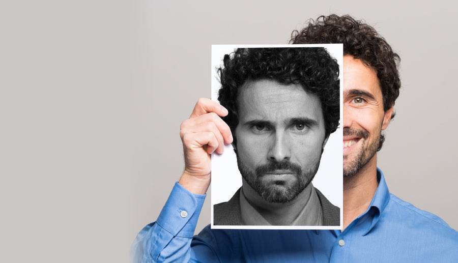 man smiling showing a picture of himself smiling