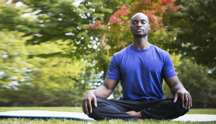man meditating in grass