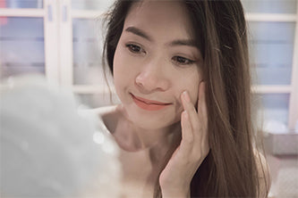 woman looking at her skin